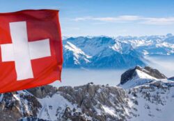 Schweizer Flagge vor einem Alpenpanorama