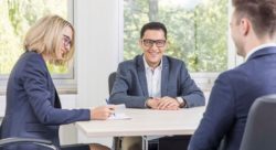 Drei Personen sitzen in einem Meeting