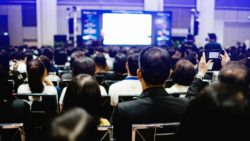 Mitarbeiter:innen hören einer Präsentation zu